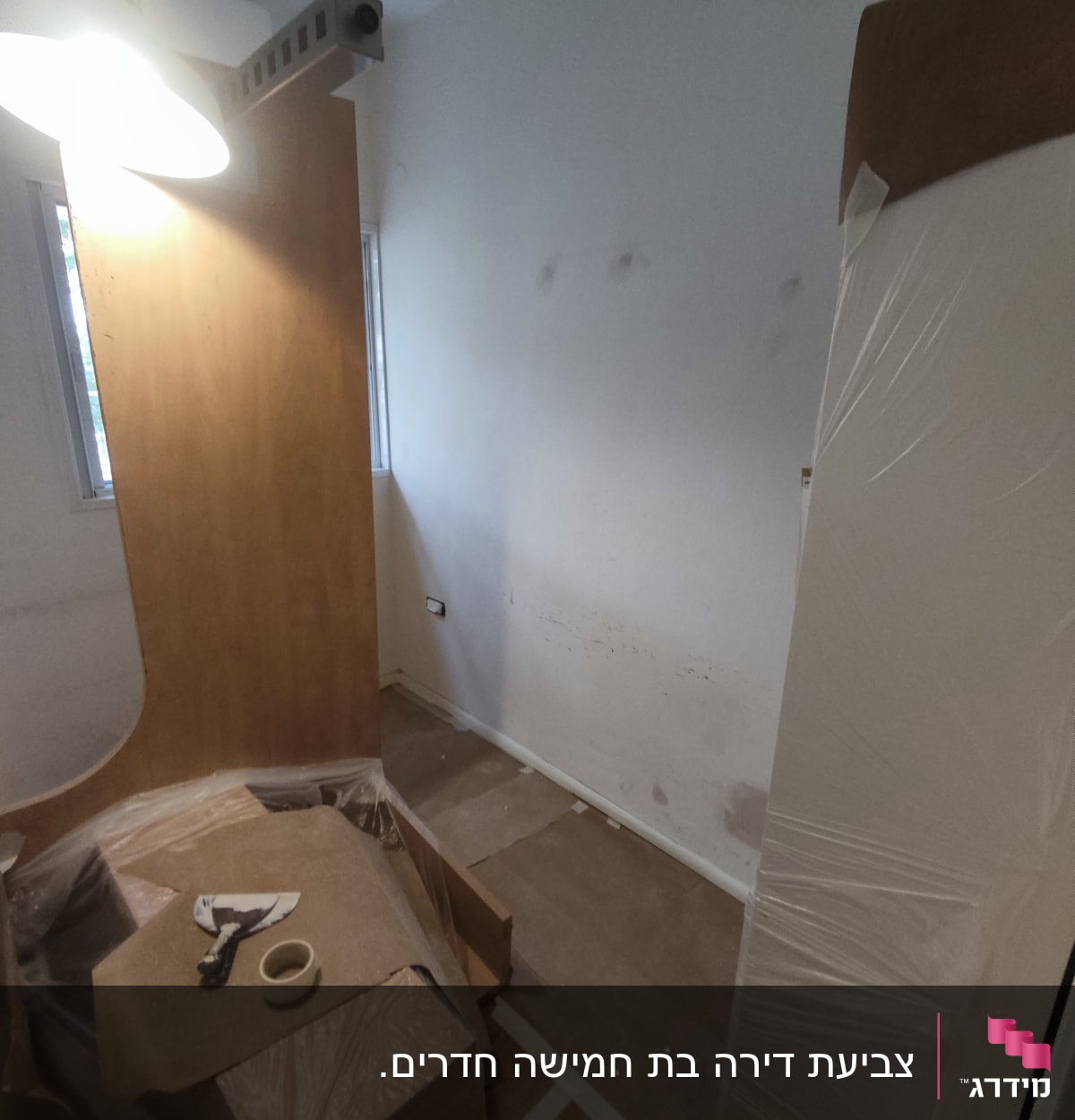 חדר עם קירות צבועים, נייר דבק וכלי עבודה